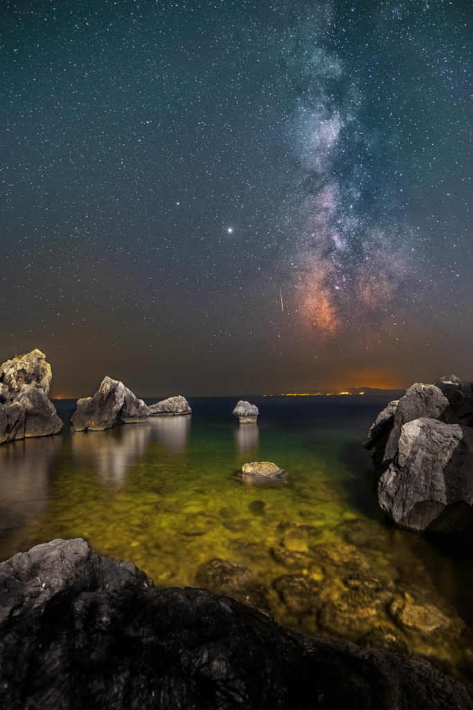 A Perseid meteor falls in front of the mikly way