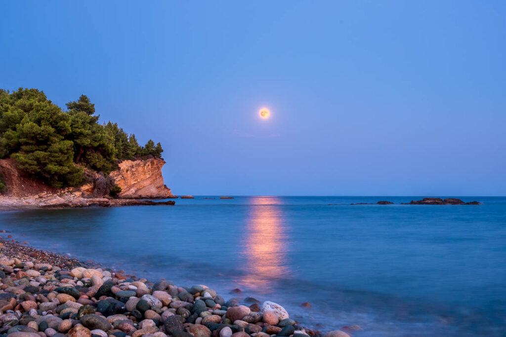 Full Moon Rising over a Rocky Beach